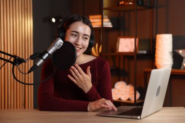 Podcast sunucusu stüdyoda talk show kaydediyor.