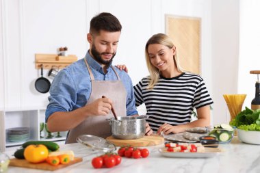 Mutfakta birlikte yemek pişiren mutlu çift.