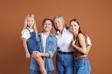 Kahverengi arka planda oğlu ve ailesi olan yaşlı bir kadının portresi.