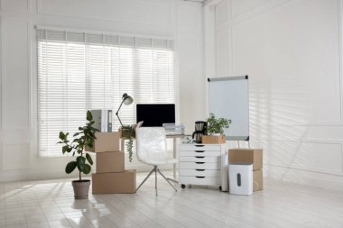 Taşınma günü. Mukavva kutular, bilgisayar ve mobilyalar ofiste.