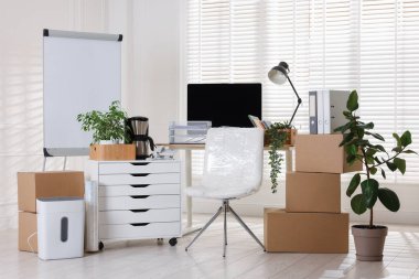 Taşınma günü. Mukavva kutular, bilgisayar ve mobilyalar ofiste.
