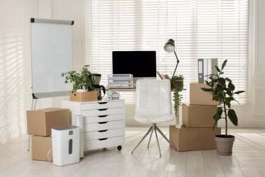 Taşınma günü. Mukavva kutular, bilgisayar ve mobilyalar ofiste.