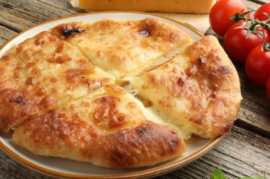 Lezzetli Megrelian Khachapuri ve ahşap masadaki ürünler, yakın plan.