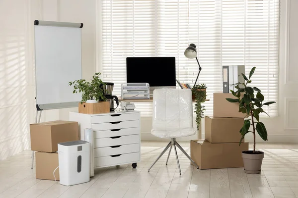 Taşınma günü. Mukavva kutular, bilgisayar ve mobilyalar ofiste.