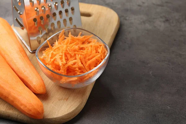 Gri masada rendelenmiş havuçlar ve rendelenmiş rendeler. Yakın plan. Metin için boşluk