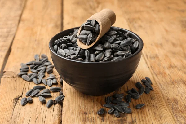 Ayçiçeği tohumları ve kepçeler ahşap masada, yakın plan