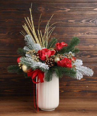 İçerideki ahşap duvarın yanında vazoda köknar ağacı dalları olan güzel bir kompozisyon. Kış Dekorasyonu