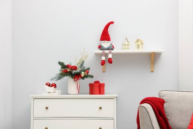 İçerideki beyaz çekmece ve diğer Noel dekorları üzerinde vazoda köknar dalları olan güzel bir kompozisyon.