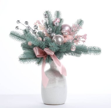 Beyaz vazoda köknar ağacı dalları olan güzel bir kompozisyon. Kış Dekorasyonu