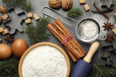Noel kompozisyonu köknar ağacı dalları, kurabiye kesiciler ve baharatlar gri masa üzerinde, düz yatıyordu