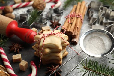 Kurabiyeli Noel kompozisyonu, köknar ağacı dalları ve gri masadaki baharatlar, yakın plan.