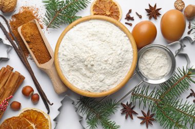 Beyaz arka planda kurabiye malzemeleri ve köknar ağacı dalları ile Noel kompozisyonu, düz yatıyordu