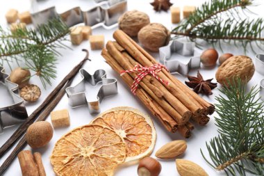 Noel kompozisyonu köknar ağacı dalları, kurabiye kesiciler ve baharatlar beyaz arka planda, yakın plan