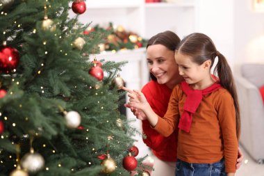 Anne ve kızı evde Noel ağacı süslüyorlar.