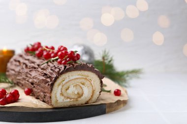 Lezzetli Noel pastası (geleneksel Noel pastası) masada bulanık ışıklar, yakın çekim ve metin için boşluk. Bokeh etkisi