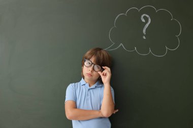 Okula dönelim. Düşünce baloncuğu ve soru işareti olan tahtaya yakın bir çocuk.