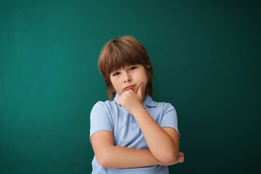 Okula dönelim. İçerideki yeşil karatahtanın yanındaki çocuk.