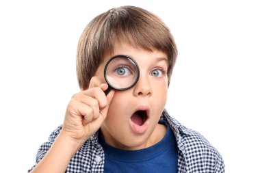 Beyaz arka planda büyüteç olan küçük çocuk şaşırdı.