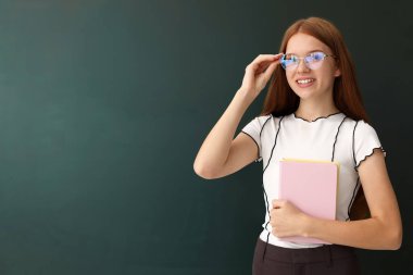 Okula dönelim. Yeşil karatahtanın yanında not defterleri olan öğrenci, metin için boşluk