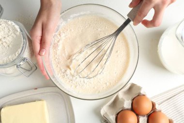 Beyaz masada hamuru yapan kadın (sıvı hamur), üst görünüm
