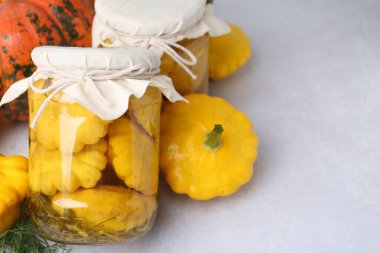 Kavanozlarda turşu kabağı turşusu ve ışık masasında taze sebzeler, yakın plan. Metin için boşluk