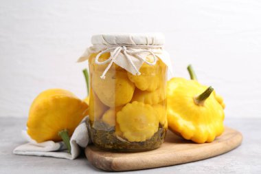 Cam kavanozda turşu kabağı turşusu ve ışık masasında taze sebzeler, yakın plan.