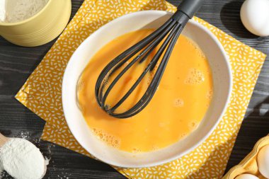 Tabakta çırpılmış yumurtalar, çırpılmış çırpılmış un masada, düz yatıyordu.