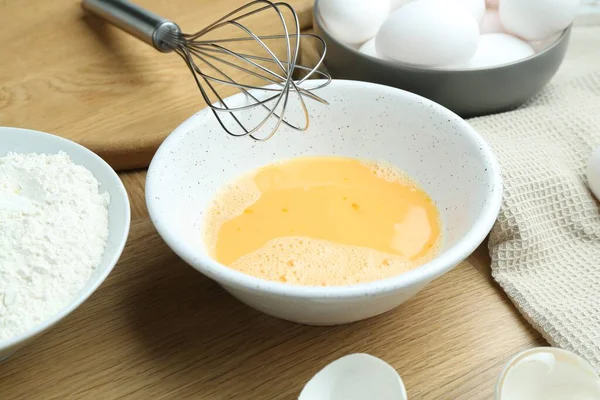 Tahta masada çırpılmış yumurta, çırpılmış çırpılmış un, yakın plan.