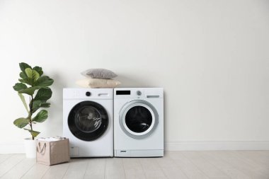 Geniş çamaşır odasında çamaşır ve çamaşır kurutma makinesi.