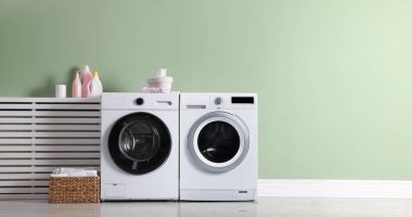 Geniş çamaşır odasında çamaşır makinesi ve çamaşır kurutma makinesi. Pankart tasarımı