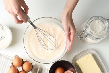 Beyaz masada hamuru yapan kadın (sıvı hamur), üst görünüm