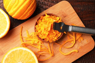 Portakal tadı, taze meyve ve zester aleti ahşap masada, düz yatıyordu.