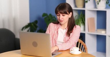 Kahve molası. Bilgisayarlı güzel bir kadın, ahşap masada kahve içiyor.