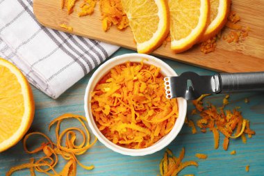 Turuncu tat, taze meyve ve zester araç açık mavi ahşap masa, düz yatıyordu