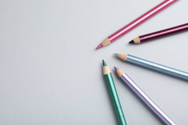 Hafif arka planda renkli göz kalemleri, düz yatış. Metin için boşluk