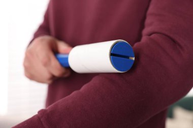 Evde iplik silindirli süveter temizleyen adam, yakın plan.