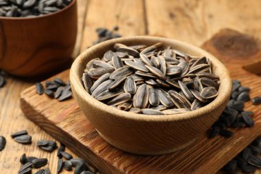 Ahşap masada soyulmamış ayçiçeği tohumları, yakın plan.