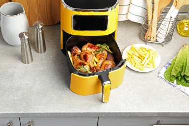 Izgara tavuk budu, patates kızartması ve gri tezgahta baharat.