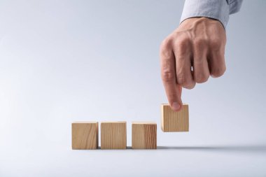 Hafif arka planda tahta küpleri olan adam, yakın plan. Metin için boşluk