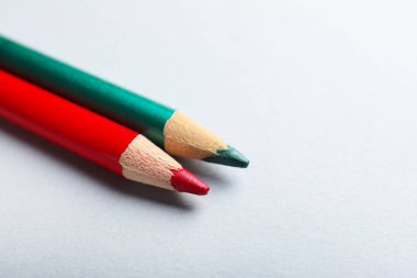 Kırmızı ve yeşil kalemler arka planda, yakın plan. Metin için boşluk