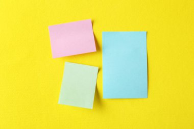 Sarı arka planda boş renkli notlar, düz yatış. Metin için boşluk