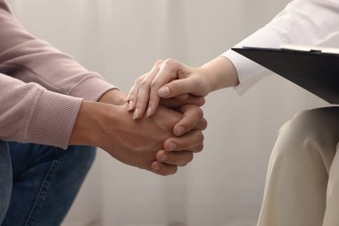 Ofiste terapi sırasında hastaya destek veren profesyonel psikolog, yakın çekim.