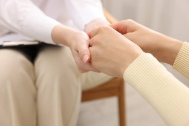 Ofiste terapi sırasında hastaya destek veren profesyonel psikolog, yakın çekim.