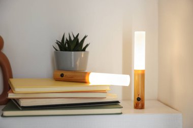 Portatif LED lambalar, kitaplar ve dekorlar beyaz rafta, yakın plan