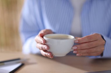 Masada kahve molası veren bir kadın, yakın plan.