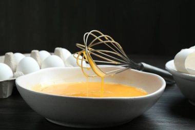 Kavanozda çırpılmış yumurtalar ve koyu ahşap masada çırpılmış çırpılmış çırpılmış çırpılmış çırpılmış, yakın plan.