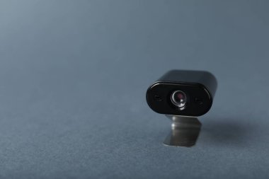 Gri arka planda gizli casus kamerası, yakın plan. Metin için boşluk