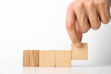 Beyaz arka planda tahta küpleri olan bir adam, yakın plan. Metin için boşluk