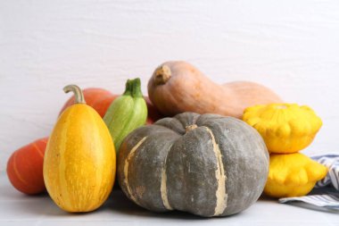 Birçok taze balkabağı ve diğer sebzeler açık fayanslı masada, yakın plan.