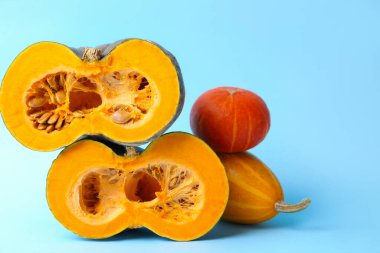 Açık mavi arkaplanda balkabaklarını kesip, mesajlaşmak için boşluk bırakarak. Su kabağı ailesi